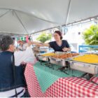 Mulher em barraca de comida serve uma cliente