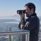Homem olha em lente de uma máquina fotográfica para tirar fotos no Mirante de Joinville
