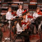 Crianças tocam violino em palco