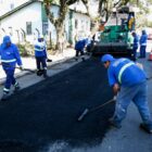 Homens uniformizados trabalham em obra de pavimentação em rua
