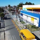 Imagem aérea de uma rua com casas, um centro de educação infantil e carros estacionados