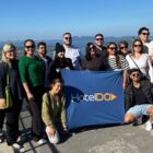 Grupo de pessoas posa para foto segurando uma bandeira no Mirante de Joinville