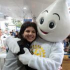 Menina abraça boneco do Zé Gotinha em terminal de ônibus