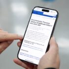 Pessoa segura celular aberto no site da Prefeitura de Joinville, com informações do processo seletivo