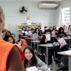 Professora fala com alunos em sala de aula