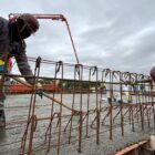 Dois homens trabalham em obra de concretagem