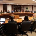 Mesa redonda com várias autoridades sentadas em volta