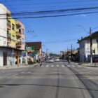 Imagem da avenida Getúlio Vargas, via asfaltada, com prédios e pedestres passando na faixa
