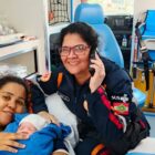 Mãe segura o bebê ao lado da atendente do SAMU, após parto dentro da ambulância