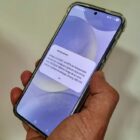 Mão segura celular com aviso de alerta severo da Defesa Civil
