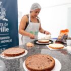 Mulher com touca e avental faz bolos