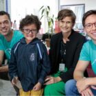 Aluno que recebeu óculos pousa para foto ao lado da equipe responsável pelo projeto