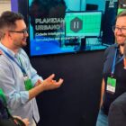 Quatro homens conversam perto de monitor que apresenta material sobre Cidade Inteligente