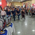 Dezenas de troféus do Parajasc posicionados à frente da imagem, com atletas e lideranças políticas sentados atrás