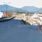 Foto de uma avenida asfaltada que vai dar em um viaduto. A avenida tem uma entrada para outra via, a rua Tuiuti