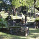Sepultadoras envoltas por gramado e árvores