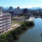 Foto do rio Cachoeira, com vegetação nas margens e um moinho perto