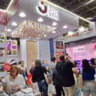 Estande com sapatilhas e flores, com a escrita Joinville, recebe várias pessoas
