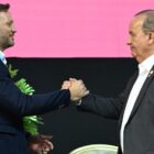 Dois homens vestidos de terno apertam as mãos