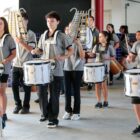 Crianças uniformizadas tocam instrumentos de fanfarra
