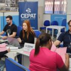 Duas pessoas sentadas são atendidas por servidores do Cepat