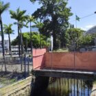 Passarela acima de rio envolta com tapumes