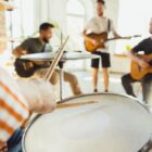 Quatro homens tocam instrumentos musicais em uma sala