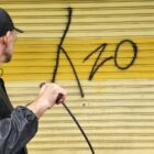 Homem limpa parede com pichação