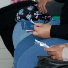 Mulher sentada segurando Carteira de Trabalho