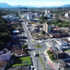 Imagem aérea mostra trecho da avenida Santos Dumont com ruas, casas, prédios e vegetação no entorno