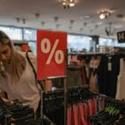 Mulher olha arara com roupas em loja