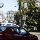 Imagem mostra carros e placas de trânsito em rua