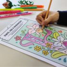 Mão segura lápis em cima de desenho com a letra F com flores