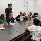 Homens e mulheres se reúnem ao redor de uma mesa