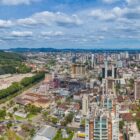 Imagem aérea de Joinville mostra prédios, ruas e vegetação