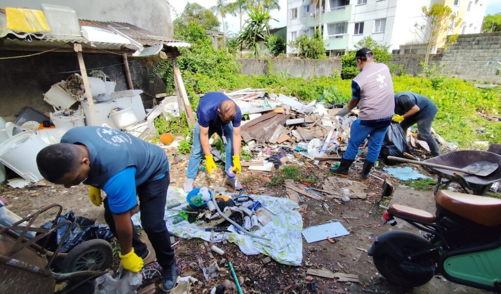 Homens recolhem resíduos descartados irregularmente em área aberta