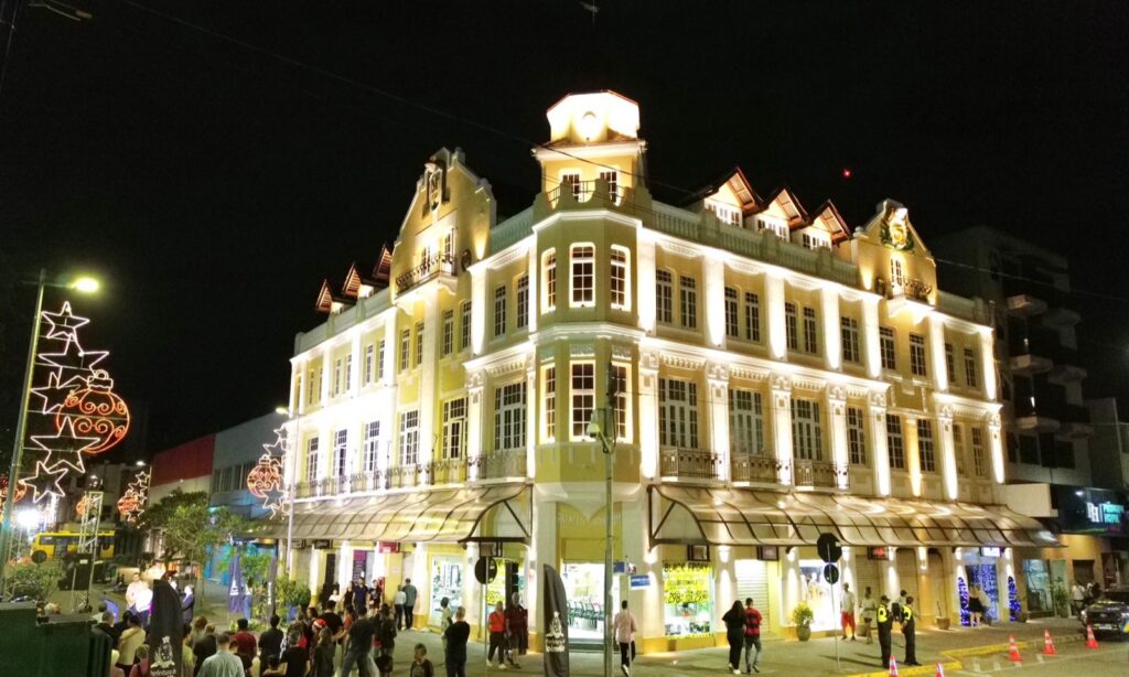 Imagem mostra o Palacete Schlemm, prédio amarelo no Centro de Joinville, iluminado