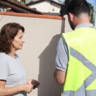 Homem de colete verde conversa com mulher