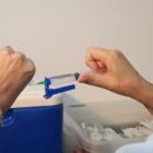 Imagem mostra as mãos de uma pessoa manipulando uma seringa