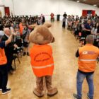 Mascote da Defesa Civil em auditório cheio de crianças