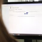 Mulher com cabelo comprido olha para tela de computador em página da Prefeitura de Joinville