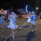 Jovens fantasiados participam de desfile natalino em rua