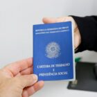 Mãos seguram carteira de trabalho