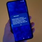 Mão segura celular que mostra alerta severo da Defesa Civil