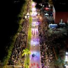 Imagem aérea de avenida com desfile de carnaval e público