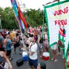Imagem mostra pessoas com roupas coloridas em avenida