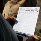 Homem segura papel com informações sobre dengue