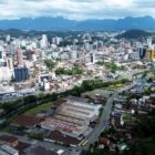 Imagem aérea de Joinville mostra prédios, rio e vegetação