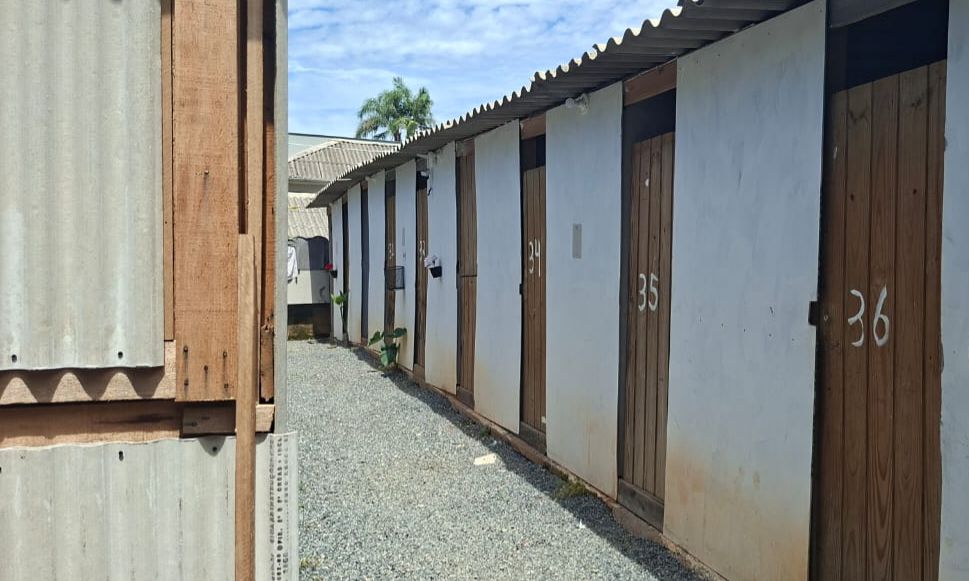 Imagem mostra imóvel com paredes brancas e portas de madeira enumeradas