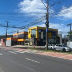 Asfalto novo em avenida com carros circulando e prédios no entorno